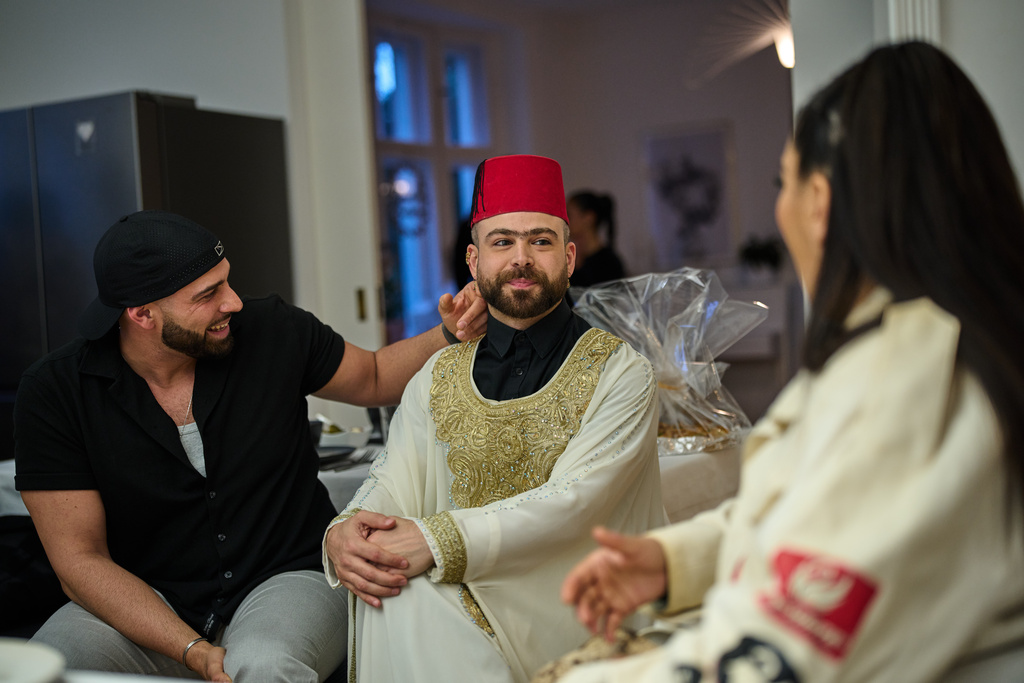 Haidar Darwish, a belly dancer and artist who came from Syria, center, attends an inclusive Iftar, the Ramadan fast-breaking meal, with friends who are Muslim, Christian, queer and straight, in Berlin, Germany, Wednesday, March 11, 2026. (AP Photo/Ebrahim Noroozi)