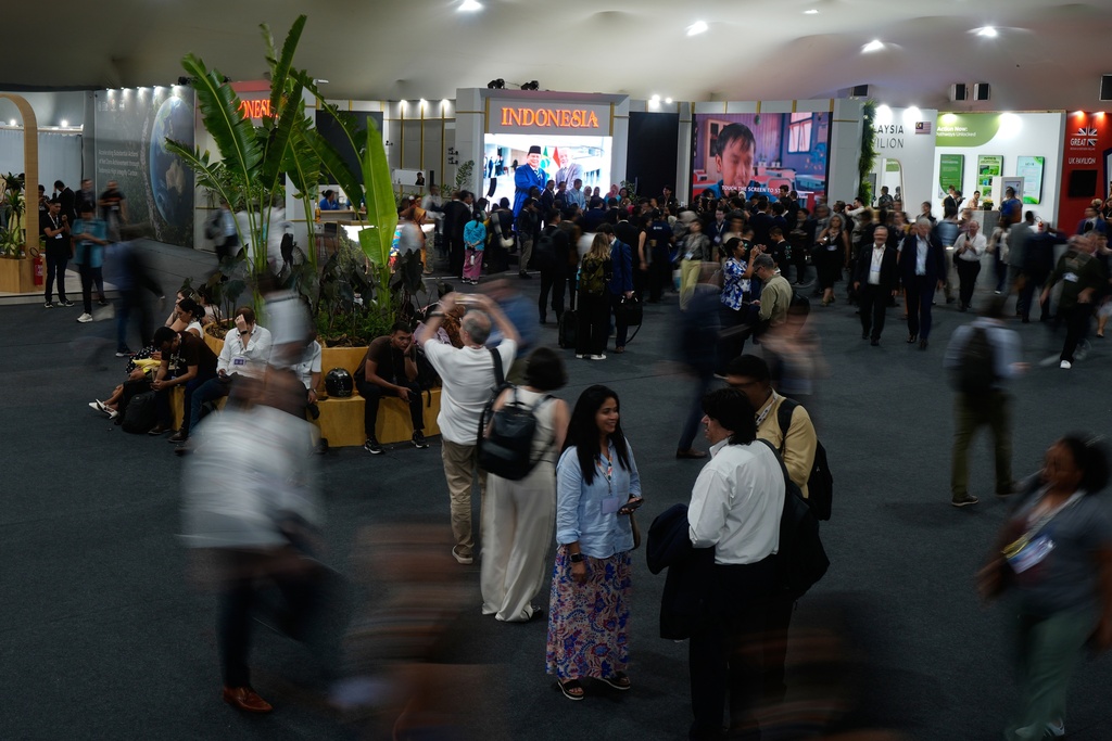 People walk outside the Indonesia Pavilion at the COP30 U.N. Climate Summit, Monday, Nov. 10, 2025, in Belem, Brazil. (AP Photo/Fernando Llano)