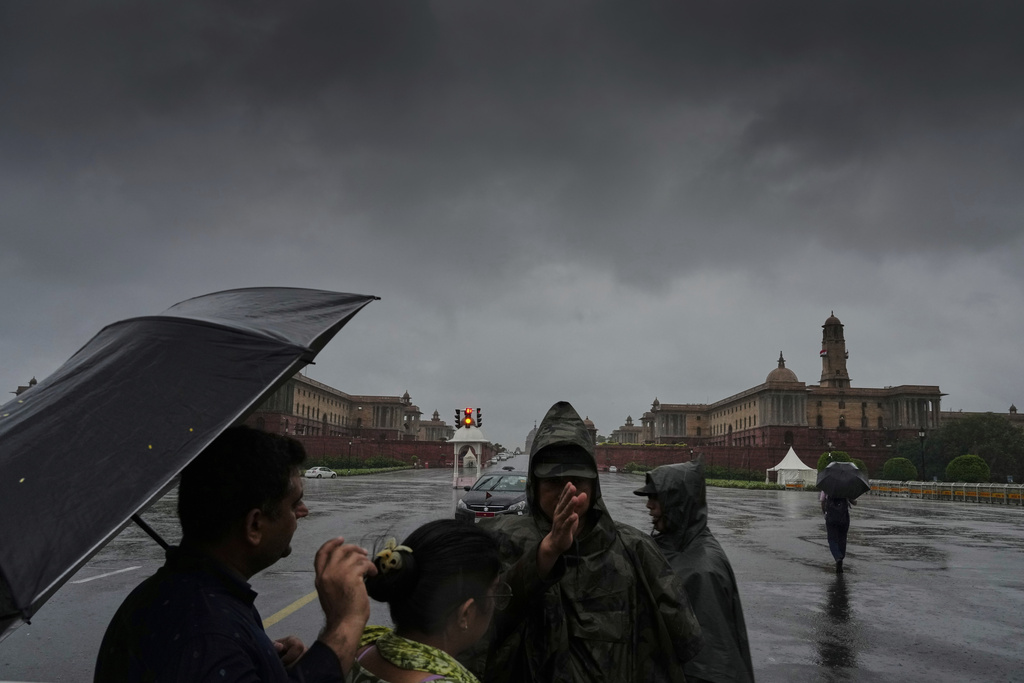 A security official on Raisina Hill, the seat of government, directs commuters to a different route amidst rain in New Delhi, India, Monday, Sept. 1, 2025. (AP Photo/Manish Swarup)
