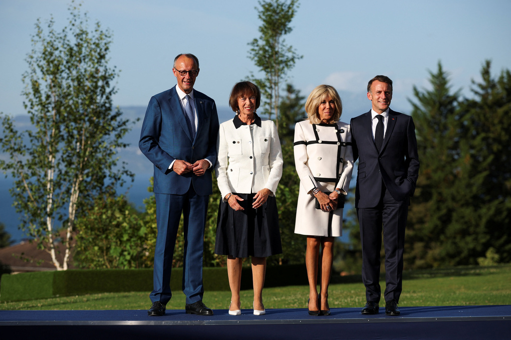 French President Emmanuel Macron, right, and his wife Brigitte Macron, second right, pose with Germany's Chancellor Friedrich Merz and his wife Charlotte Merz during the G7 summit in Evian-les-Bains, France, Monday, June 15, 2026. (Isabel Infantes/Pool Photo via AP)