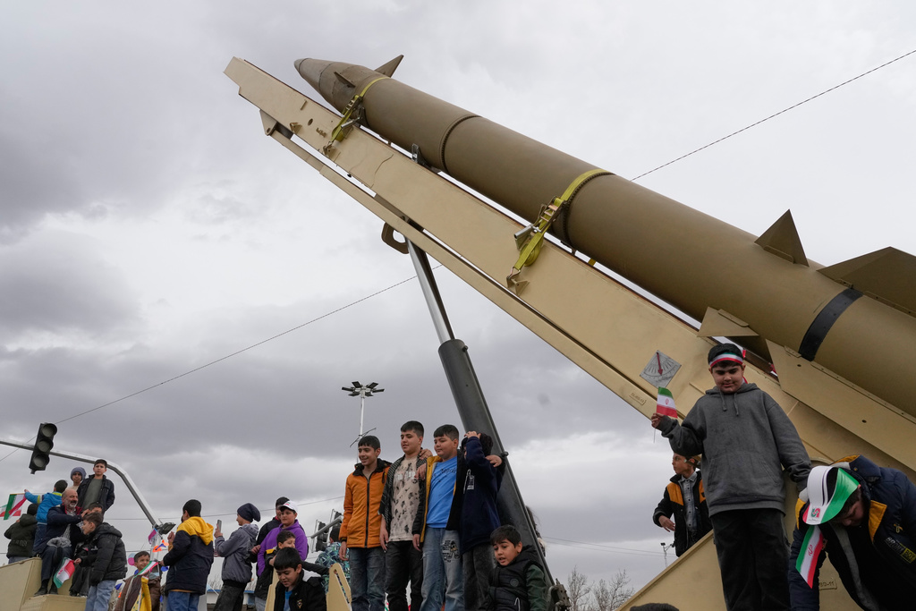 FILE - Boys stand on a launcher of an Iranian domestically-built missile during an annual rally marking 1979 Islamic Revolution at the Azadi (Freedom) sq. in Tehran, Iran, Feb. 11, 2026. (AP Photo/Vahid Salemi, file)