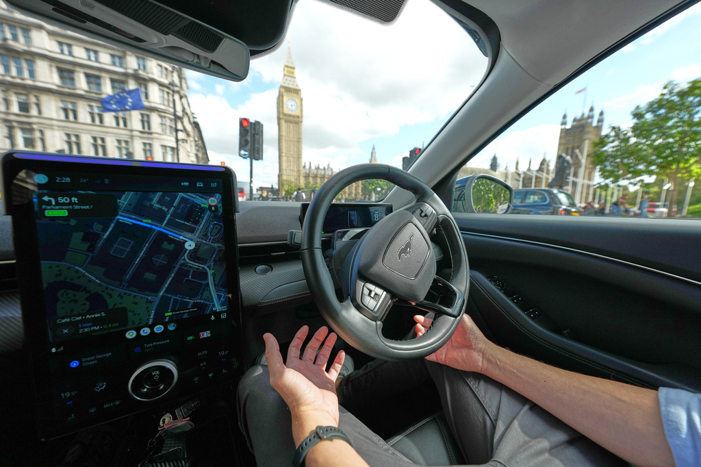 An Uber driver has his hands ready for intervention as he sits in an autonomous car in London, Tuesday, Sept. 1, 2026 as Uber officially launches the first hailable autonomous cabs in London.(AP Photo/Frank Augstein)