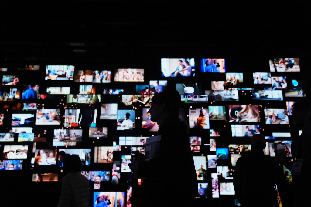 People walk past screens at the LG Electronics booth during the CES tech show Tuesday, Jan. 6, 2026, in Las Vegas. (AP Photo/Abbie Parr)