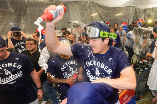 Los Angeles Dodgers' Shohei Ohtani, right, celebrates in the clubhouse after a win over the Cincinnati Reds in Game 2 of the National League Wild Card baseball playoff series Wednesday, Oct. 1, 2025, in Los Angeles. (AP Photo/Mark J. Terrill) Los Angeles Dodgers' Shohei Ohtani, right, celebrates in the clubhouse after a win over the Cincinnati Reds in Game 2 of the National League Wild Card baseball playoff series Wednesday, Oct. 1, 2025, in Los Angeles. (AP Photo/Mark J. Terrill)