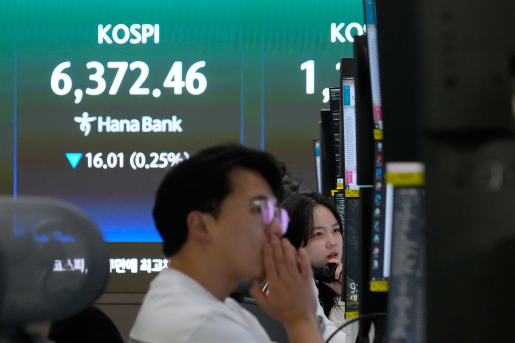 A currency trader talks on the phone near a screen showing the Korea Composite Stock Price Index (KOSPI) at the foreign exchange dealing room of the Hana Bank headquarters in Seoul, South Korea, Wednesday, April 22, 2026. (AP Photo/Ahn Young-joon)