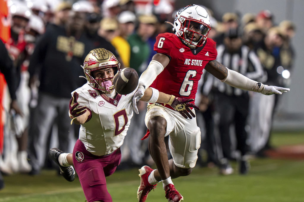 North Carolina State defensive back Devon Marshall (6) disrupts a pass intended for Florida State wide receiver Duce Robinson (0) during the second half of an NCAA college football game, Friday, Nov. 21, 2025, in Raleigh, N.C. (AP Photo/David Yeazell)