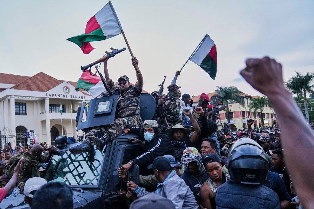 Soldiers are greeted by people gathering for a ceremony in tribute to demonstrators killed during recent anti-government protest in Antananarivo, Madagascar, Sunday, Oct. 12, 2025. (AP Photo/Mamyrael)