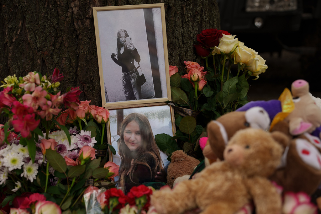 Photos of a girl who was killed are seen among flowers near a heavily damaged house after a Russian strike on a residential neighborhood in Kyiv, Ukraine, Friday, May 15, 2026. (AP Photo/Evgeniy Maloletka)