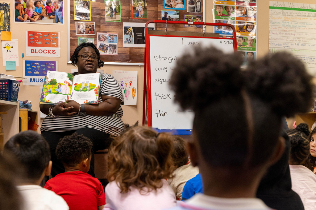 Assistant lead teacher Yolanda Maheia reads a book to a group of preschool students at The Capitol Hill Child Enrichment Center, Wednesday, April 22, 2026, in Atlanta. (AP Photo/Alyssa Pointer)