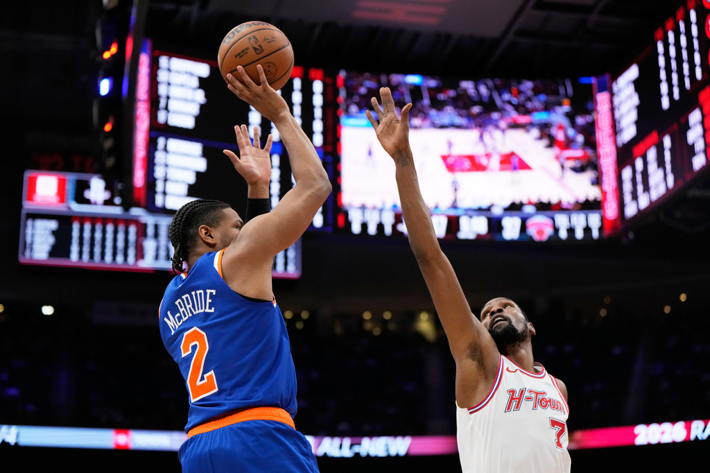 New York Knicks guard Miles McBride (2) shoots against Houston Rockets forward Kevin Durant (7) during the first half of an NBA basketball game in Houston, Tuesday, March 31, 2026. (AP Photo/Ashley Landis)