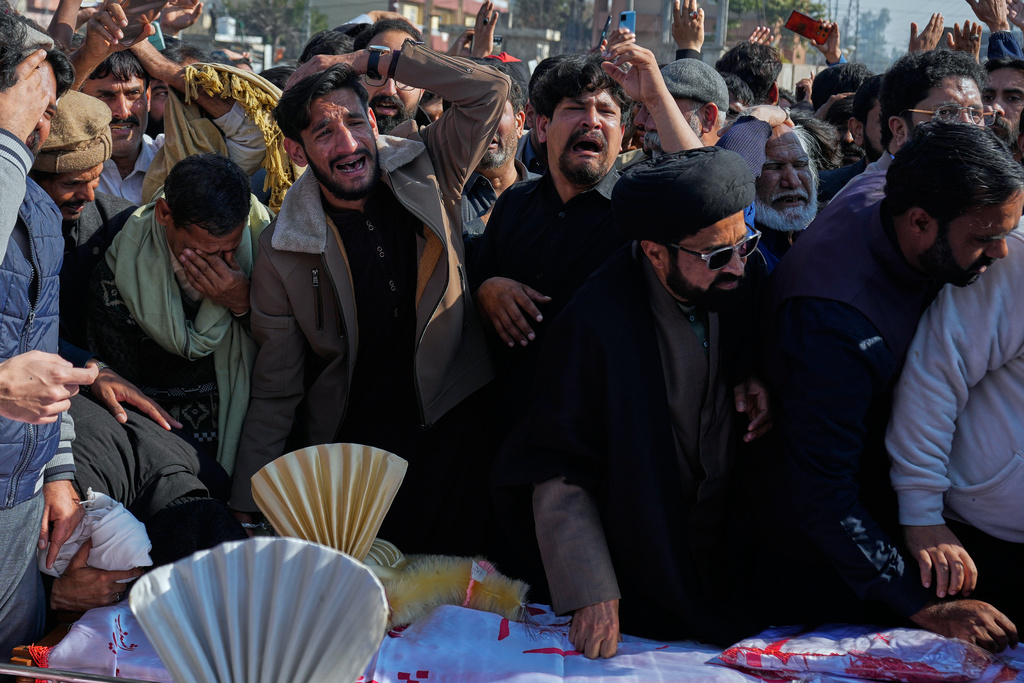 People mourn next the coffin of their relatives, who were killed in Friday's suicide bombing inside a Shiite mosque, in Islamabad, Pakistan, Saturday, Feb. 7, 2026. (AP Photo/Anjum Naveed)