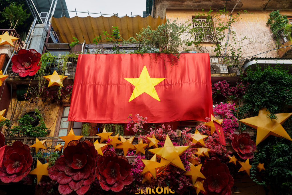 FILE - A giant Vietnamese national flag hangs from a balcony in the old quarter of Hanoi, Vietnam, Monday, Sept. 1, 2025. (AP Photo/Vincent Thian, File)