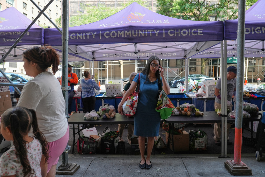 Marlyn Garcia collects food from the West Side Campaign Against Hunger's food distribution center in New York on Tuesday, June 30. (AP Photo/Mary Conlon)