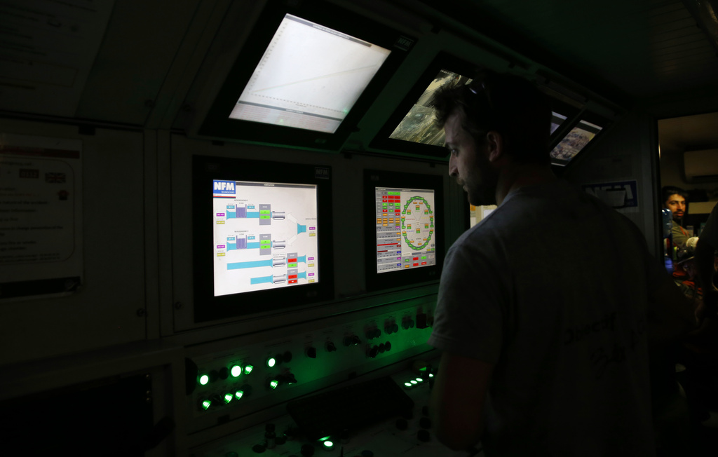 FILE- An engineer works in a pilot cabin of a 140-meter-long rock-eating machine dubbed "Federica" in a Turin-Lyon high-speed rail tunnel (TAV) in Saint Martin La Porte, France, Feb. 12, 2019. (AP Photo/Antonio Calanni, File)