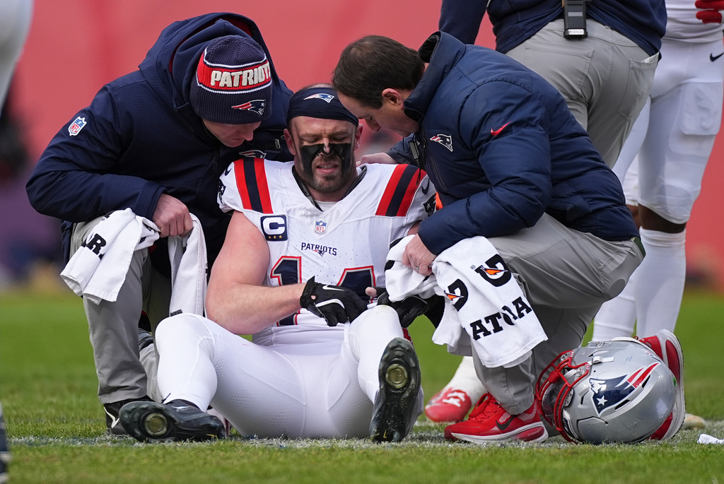 New England Patriots linebacker Robert Spillane sits on the turf and an injury against the Denver Broncos during the first half of the AFC Championship NFL football game, Sunday, Jan. 25, 2026, in Denver. (AP Photo/David Zalubowski)
