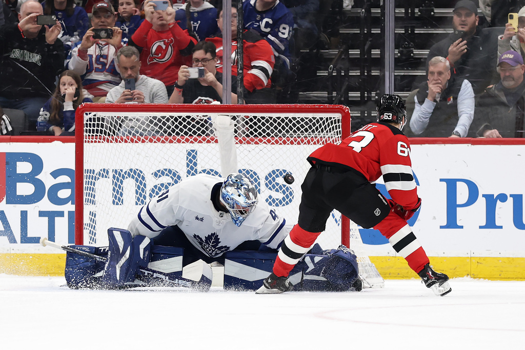 New Jersey Devils left wing Jesper Bratt (63) scores a goal past Toronto Maple Leafs goaltender Anthony Stolarz during a shootout of an NHL hockey game, Wednesday, March 4, 2026, in Newark, N.J. (AP Photo/Adam Hunger)