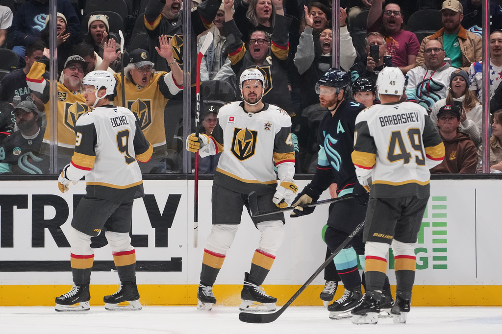 Vegas Golden Knights center Tomas Hertl, second from left, reacts with center Jack Eichel (9) and left wing Ivan Barbashev (49) after he scored a goal against the Seattle Kraken during the third period of an NHL hockey game, Tuesday, Oct. 6, 2026, in Seattle. (AP Photo/Lindsey Wasson)