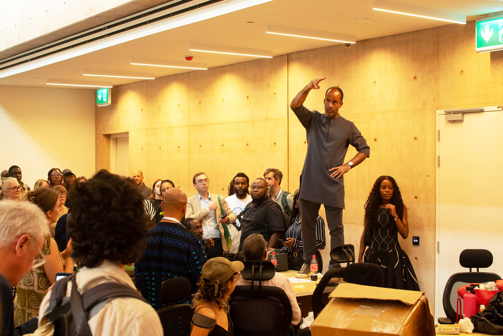 A man speaks to guests to calm down during the soft launch of the new, state backed, Museum of West African Arts, that was disrupted by protesters in Benin City, Nigeria, Sunday, Nov. 9, 2025. (AP Photo/Akpobasaha Oghenemaro Godspower )