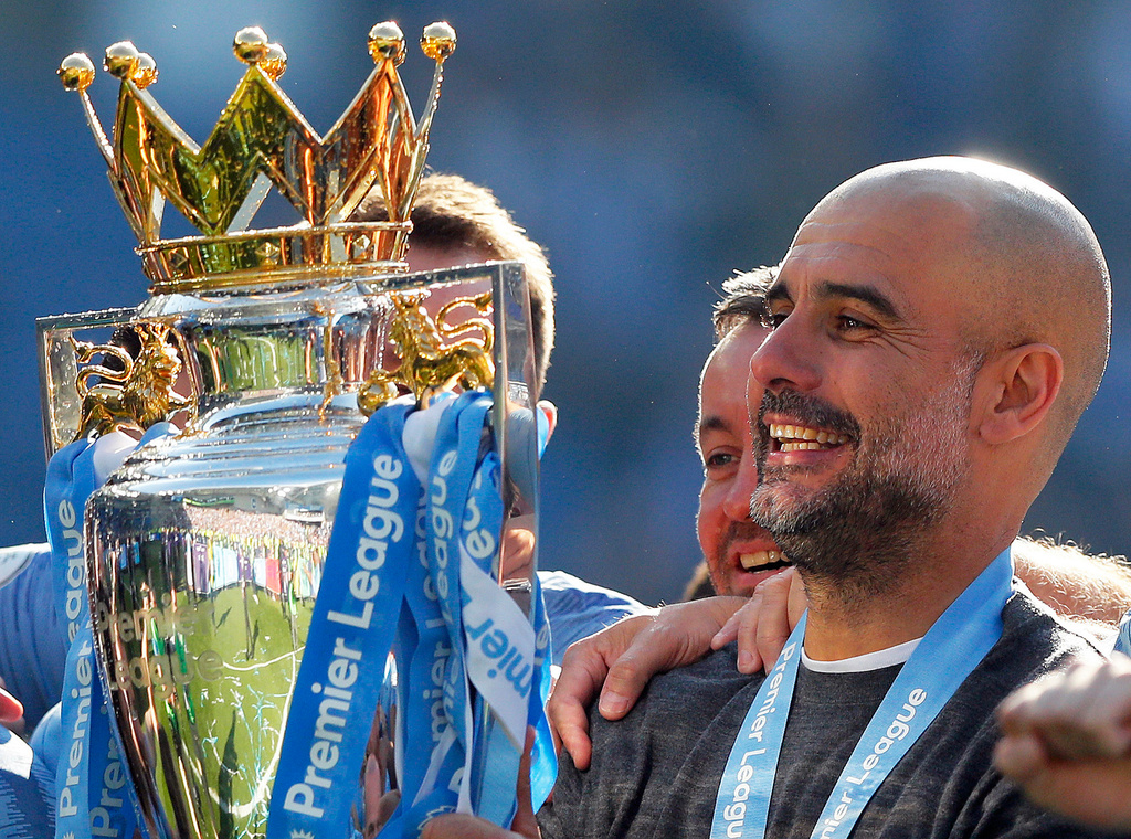 FILE - Manchester City coach Pep Guardiola lifts the English Premier League trophy after the English Premier League soccer match between Brighton and Manchester City at the AMEX Stadium in Brighton, England, Sunday, May 12, 2019. (AP Photo/Frank Augstein, File)