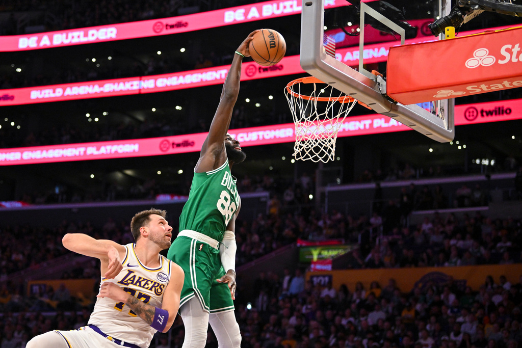 Boston Celtics center Neemias Queta, right, dunks the ball against Los Angeles Lakers guard Luka Doncic, left, during the first half of an NBA basketball game Sunday, Feb. 22, 2026, in Los Angeles. (AP Photo/Katie Chin)