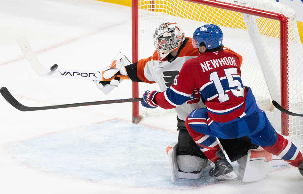 Philadelphia Flyers goaltender Dan Vladar (80) stops a shot as Montreal Canadiens' Alex Newhook (15) looks for a rebound during second period NHL hockey action in Montreal on Tuesday, Nov. 4, 2025. (Christinne Muschi/The Canadian Press via AP)