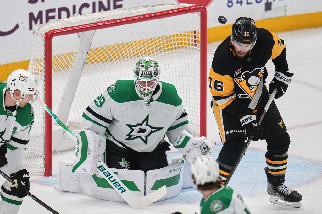 Pittsburgh Penguins' Justin Brazeau (16) deflects a shot in front of Dallas Stars goaltender Jake Oettinger (29) during the first period of an NHL hockey game in Pittsburgh, Saturday, March 28, 2026. (AP Photo/Gene J. Puskar)