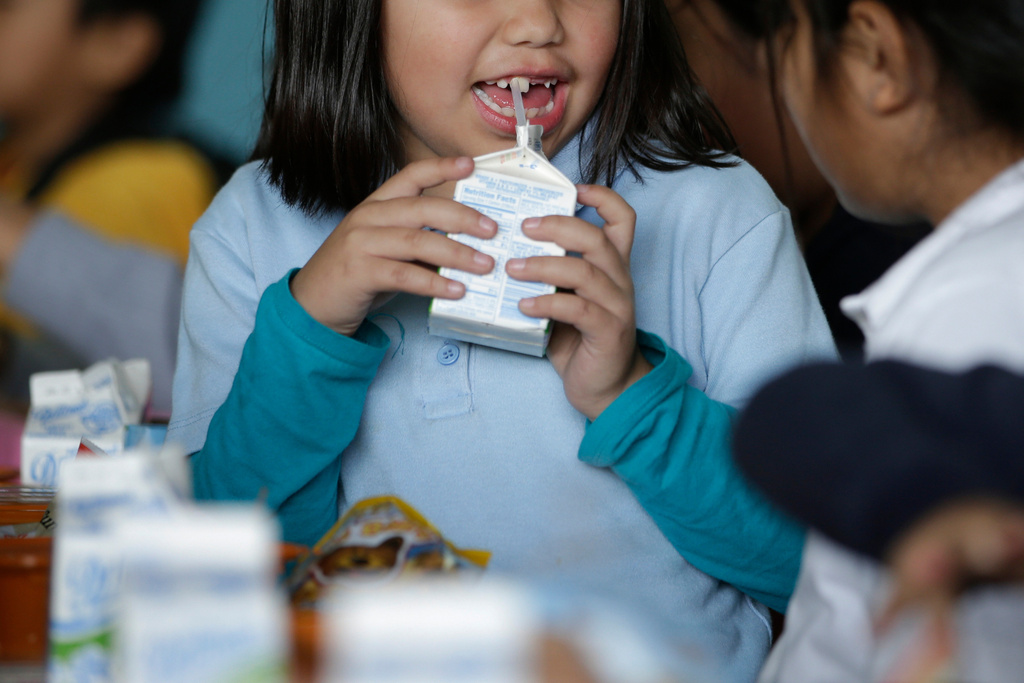 FILE - A student drinks milk in the cafeteria area of an elementary school in Los Angeles on Tuesday, Jan. 13, 2015. (AP Photo/Jae C. Hong, File)