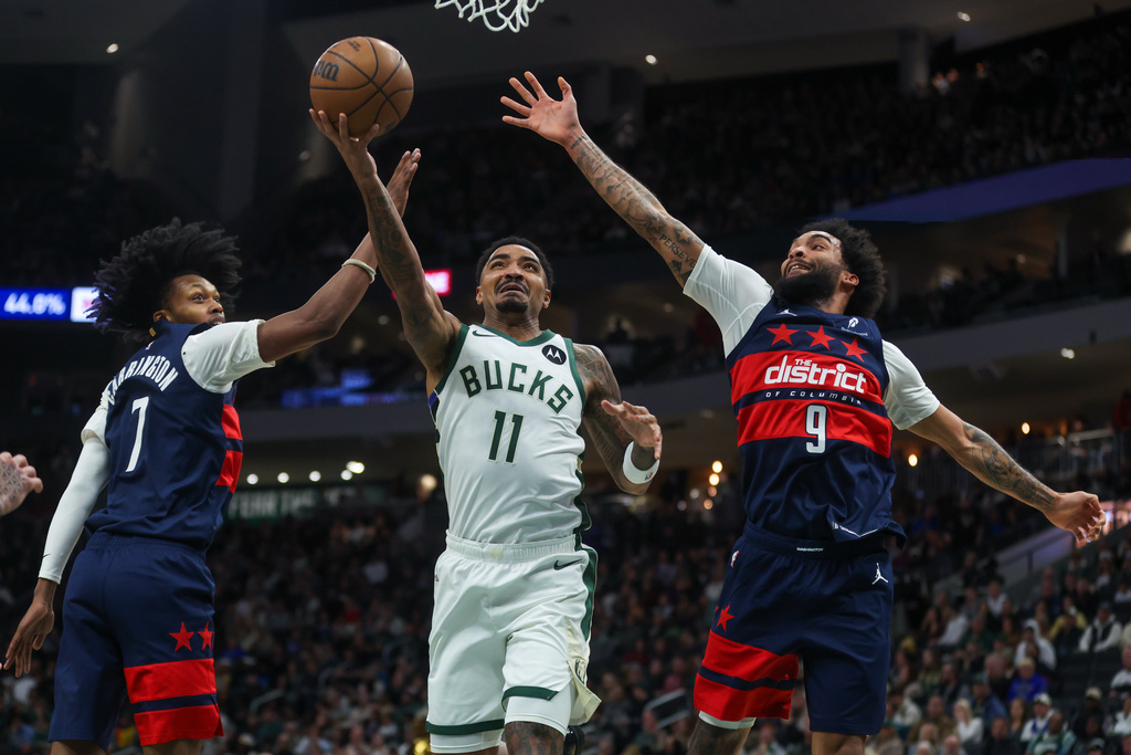 Milwaukee Bucks' Gary Harris drives to the basket between Washington Wizards' Bub Carrington and Justin Champagnie during the first half of an NBA basketball game, Wednesday, Dec. 31, 2025, in Milwaukee. (AP Photo/Kylie Bridenhagen)