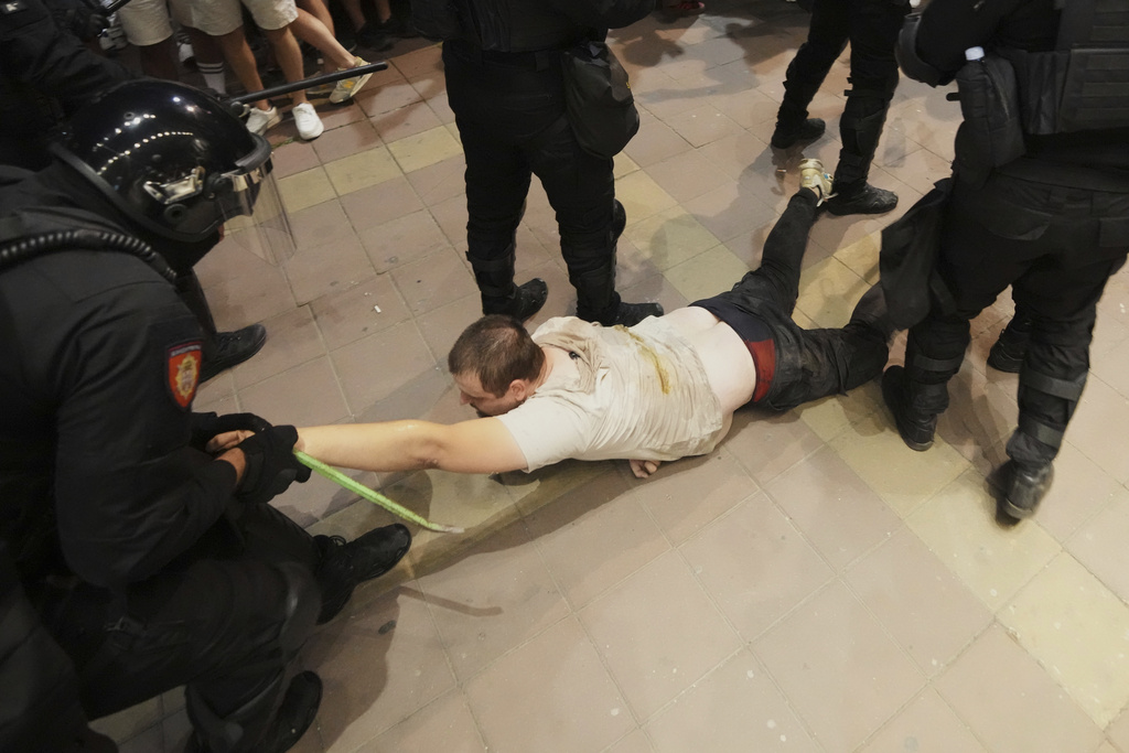 Serbian gendarmerie officers detain an alleged pro-government supporter during an anti-government protest in Belgrade, Serbia, Wednesday, Aug. 13, 2025. (AP Photo/Darko Vojinovic)