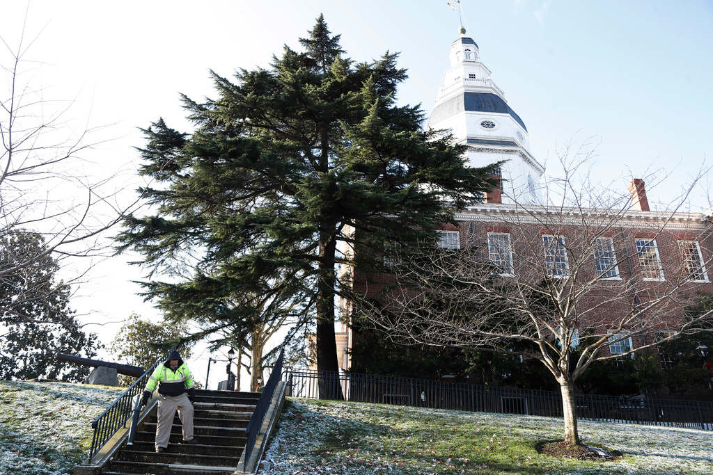 FILE - A worker blows leaves and snow off steps outside of the Maryland Statehouse on the morning of the first day of the state's 2020 legislative session, Jan. 8, 2020, in Annapolis, Md. (AP Photo/Julio Cortez, File)
