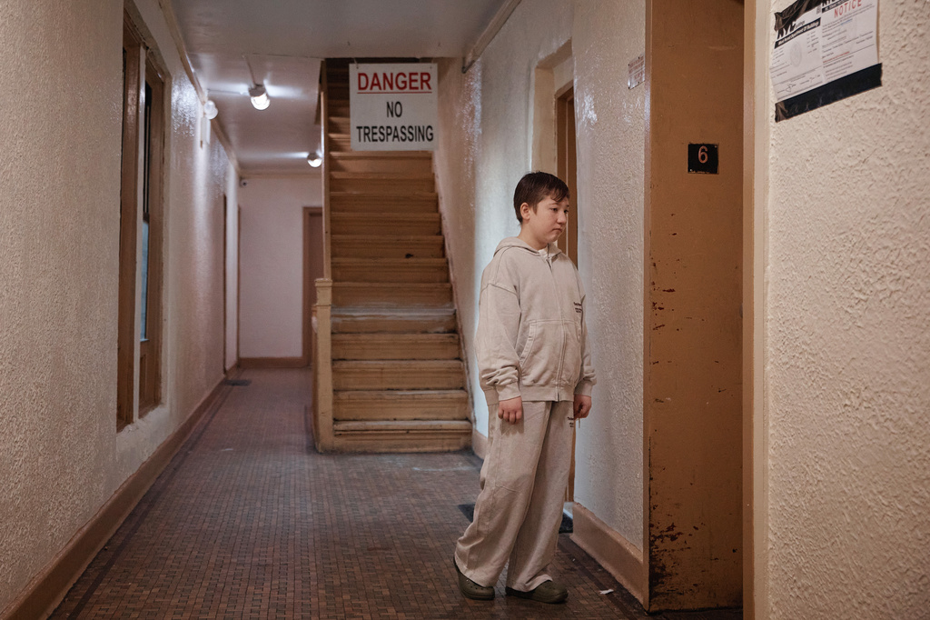 Gulhayo Yuldosheva's son, Heriberto, 11, stands in an apartment building where tenants report maintenance issues and pest infestations, in the Bronx borough of New York, Tuesday, March 17, 2026. (AP Photo/Andres Kudacki)