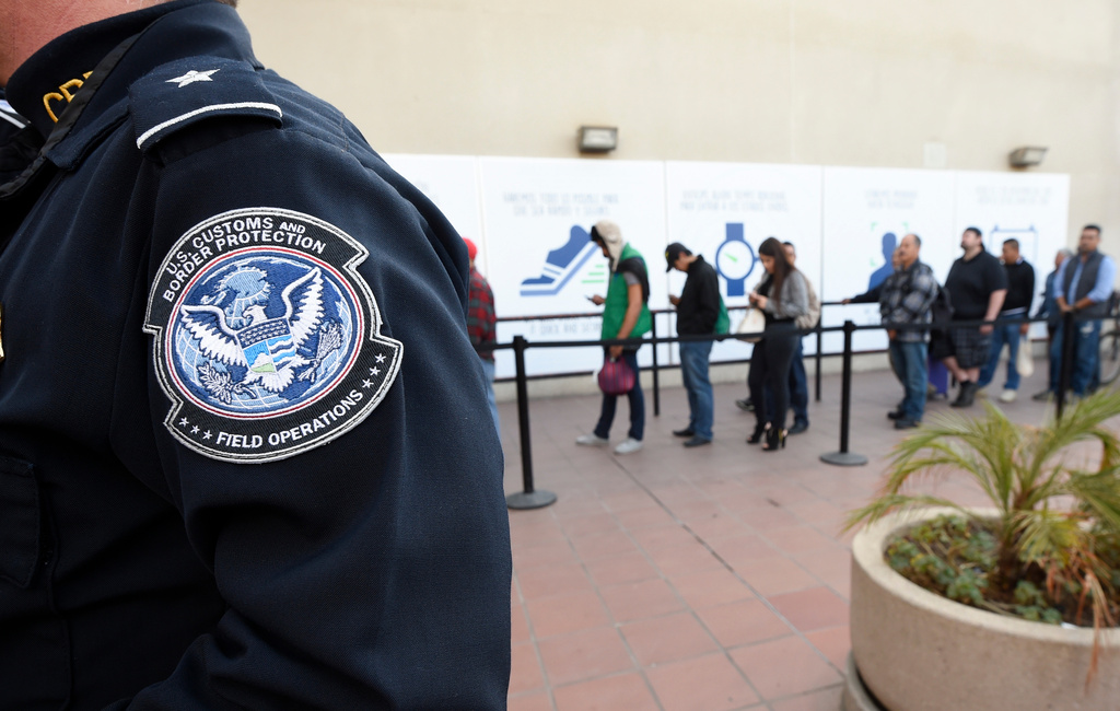 FILE - Pedestrians crossing from Mexico into the United States at the Otay Mesa Port of Entry wait in line in San Diego, Dec. 10, 2015. (AP Photo/Denis Poroy, File)
