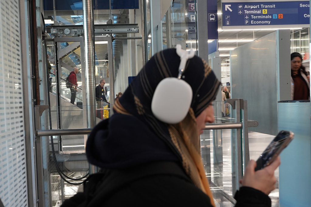 A traveler checks the status of their flight at O'Hare International Airport in Chicago, Friday, Nov. 7, 2025. (AP Photo/Nam Y. Huh)