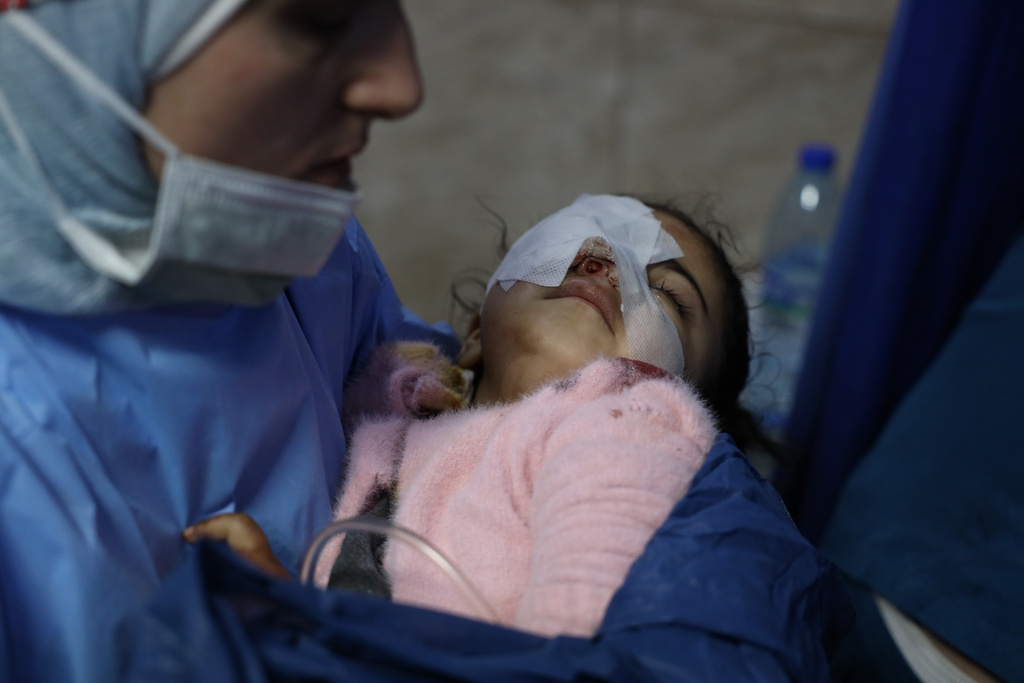 A nurse carries, Fatima al-Zahra Abu Sheikh, 4, a Syrian child who was wounded in clashes that broke out between Syrian government forces and Kurdish fighters in a contested area of the northern city of Aleppo, Syria, Tuesday, Jan. 6, 2026. (AP Photo/Omar Albam)