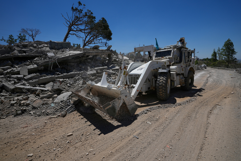 A bulldozer for the Spanish U.N peacekeeper opens a road in front of a house that was destroyed in the recent clashes between Hezbollah fighters and Israeli troops in Dibbine village, southeast Lebanon, Friday, June 5, 2026, a day after Israeli forces withdrew. (AP Photo/Hussein Malla)