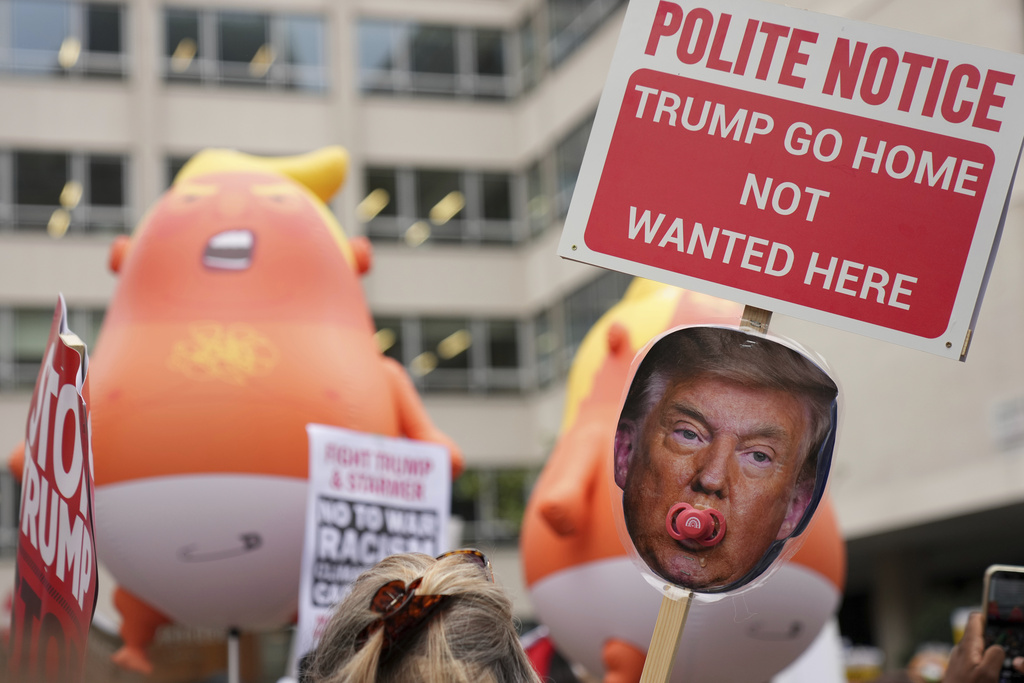 People show placards at a protest of the Stop Trump Coalition group against President Donald Trump's state visit in London, Wednesday, Sept. 17, 2025.(AP Photo/Joanna Chan)