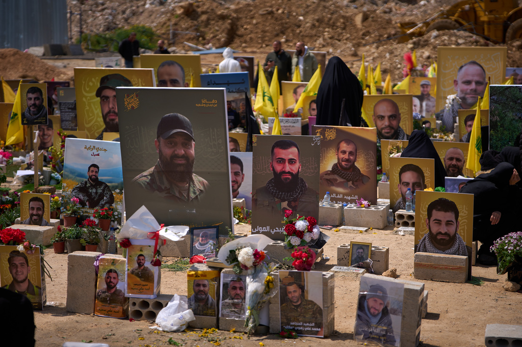 Graves bearing photos of Hezbollah fighters killed in Israeli strikes are seen in a cemetery in Choueifat, Lebanon, Monday, April 13, 2026. (AP Photo/Emilio Morenatti)