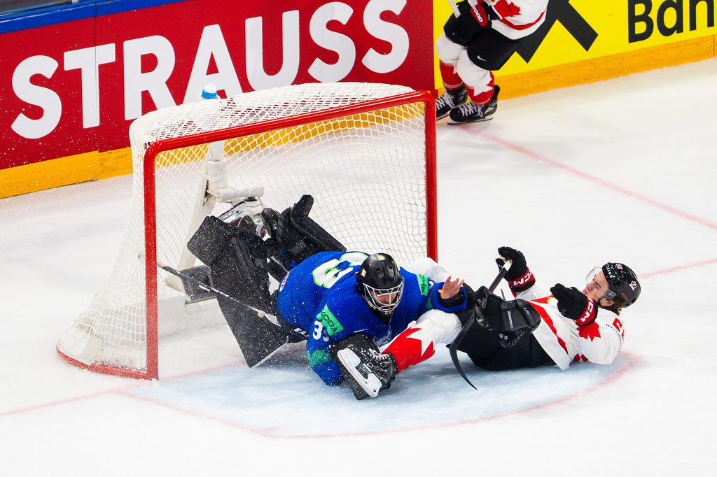 Canada's Emmitt Finnie, right, clashes against Slovenia's goaltender Zan Us during a preliminary round game between Canada and Slovenia at the men's ice hockey world championship in Fribourg, Switzerland, Friday May 22, 2026. (Salvatore Di Nolfi/Keystone via AP)