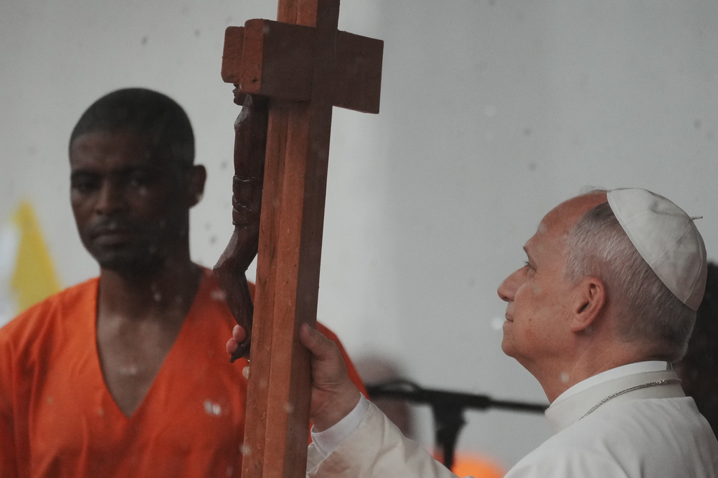 Pope Leo XIV holds a cross as he visits the Bata Prison, Equatorial Guinea, Wednesday, April 22, 2026. (AP Photo/Andrew Medichini)