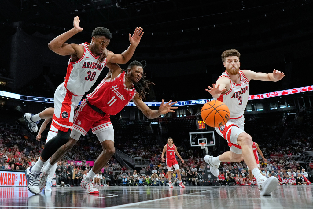 Houston's Joseph Tugler (11) chases a loose ball between Arizona's Tobe Awaka (30) and Anthony Dell'Orso (3) during the first half of an NCAA college basketball game in the championship of the Big 12 Conference tournament Saturday, March 14, 2026, in Kansas City, Mo. (AP Photo/Charlie Riedel)