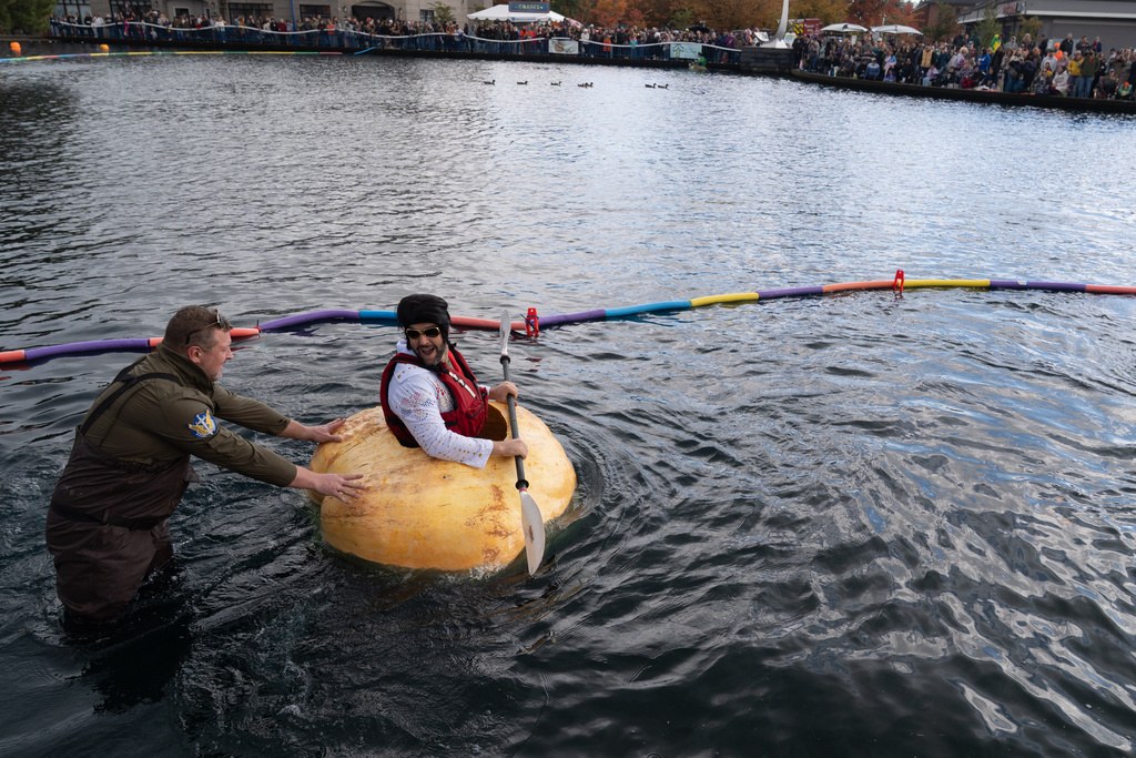 Jon Sestak, dressed as Elvis, is helped out of the loading area ahead of his race during the West Coast Giant Pumpkin Regatta on Sunday, Oct. 19, 2025, in Tualatin, Ore. (AP Photo/Jenny Kane)