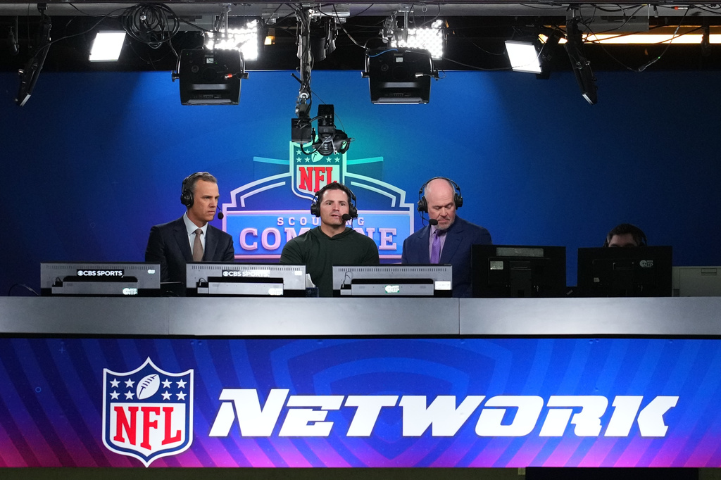 FILE - Seattle Seahawks head coach Mike Macdonald, center, talks on an NFL Network show in Indianapolis, Feb. 26, 2026. (AP Photo/Julio Cortez, File)