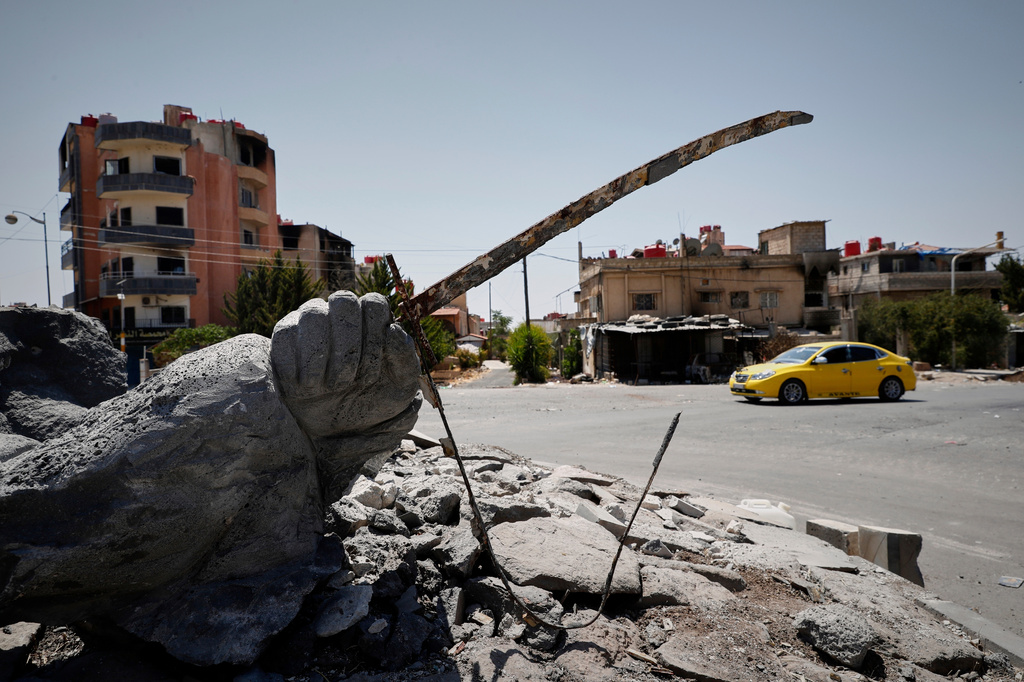 FILE - A car drives by a destroyed statue in the Druze-majority town of Sweida, Syria, Friday, July 25, 2025. (AP Photo/Omar Sanadiki, File)