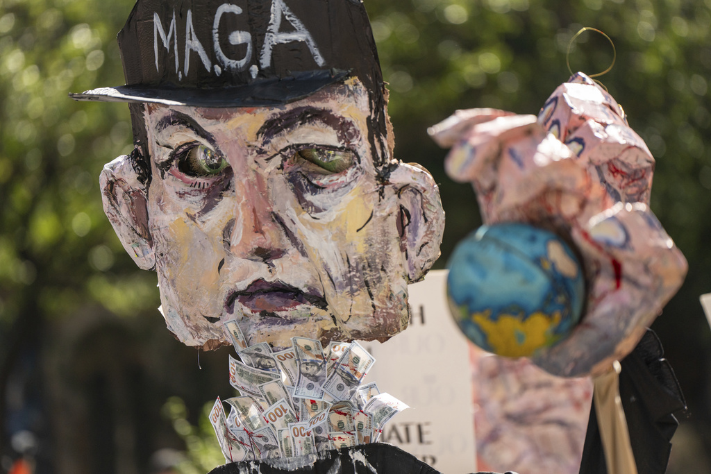 An effigy representing Elon Musk with a bloody hand holding a globe is marched through Manhattan at the "Make Billionaires Pay" climate protest in New York, Saturday, Sept. 20, 2025. (AP Photo/Angelina Katsanis)
