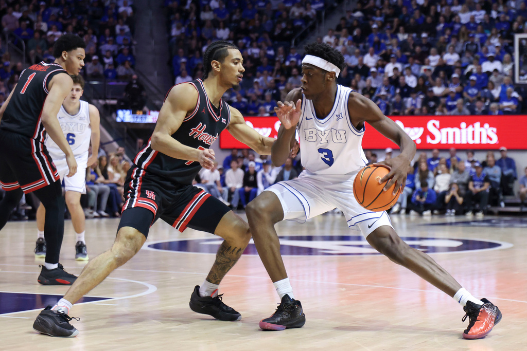 BYU forward AJ Dybantsa (3) dribbles the ball against Houston guard Milos Uzan, left, during the first half of an NCAA college basketball game, Saturday, Feb. 7, 2026, in Provo, Utah. (AP Photo/Rob Gray)