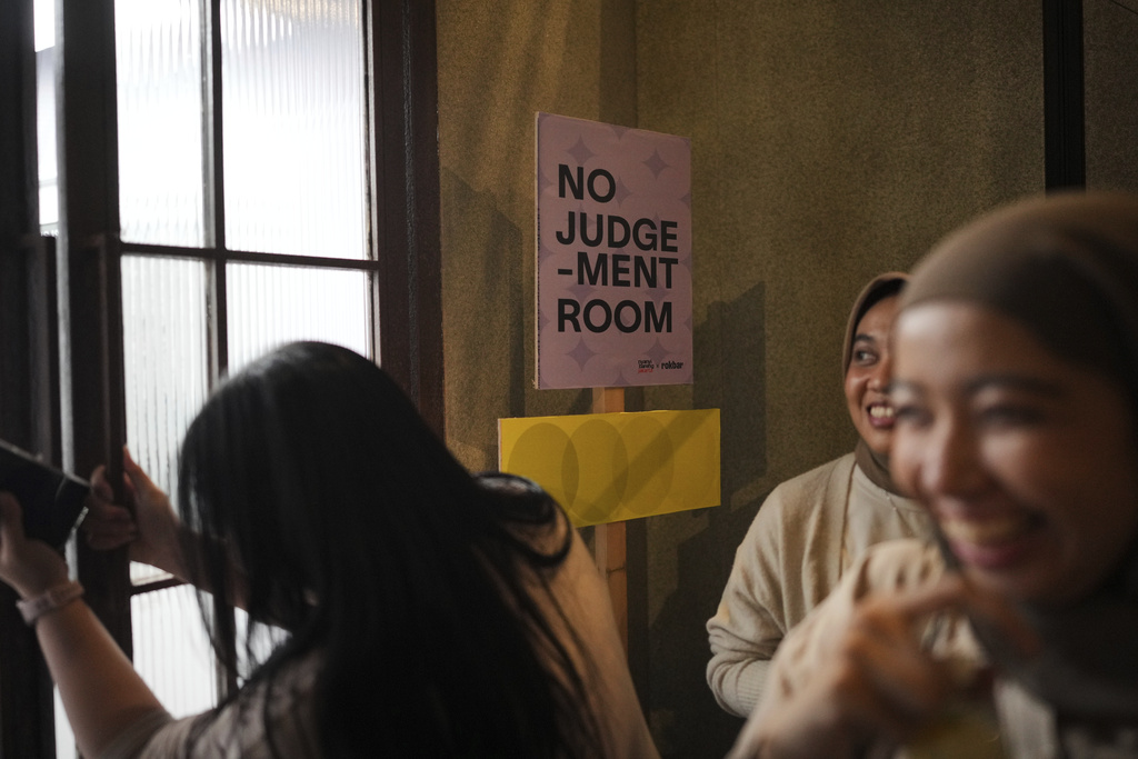 Participants enter a "No Judgement Room" where they sing and express themselves during a gathering of "Nyanyi Bareng Jakarta" or "Singing Together Jakarta" community in Jakarta, Indonesia, Saturday, July 19, 2025. (AP Photo/Dita Alangkara)