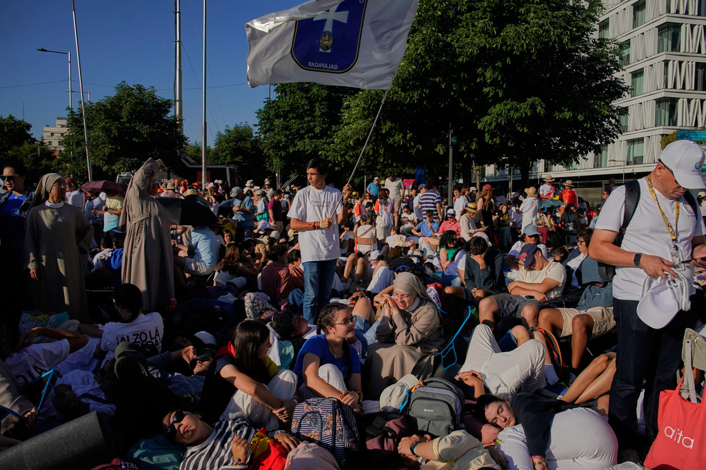 People wait for the arrival of Pope Leo XIV ahead of a Holy Mass and Corpus Christi procession at Plaza de Cibeles in Madrid, Spain, Sunday, June 7, 2026, on the second day of his seven-day apostolic visit to mainland Spain and the Canary Islands. (AP Photo/Andrea Comas)