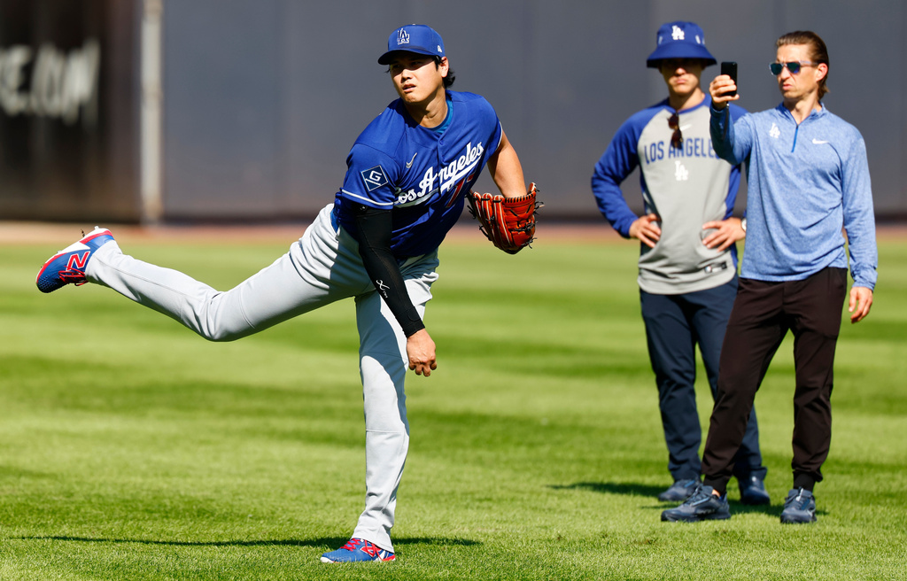 Los Angeles Dodgers' Shohei Ohtani, left, throws in the outfield before the second game of a baseball doubleheader against the New York Yankees, Sunday, July 19, 2026, in New York. (AP Photo/Noah K. Murray)