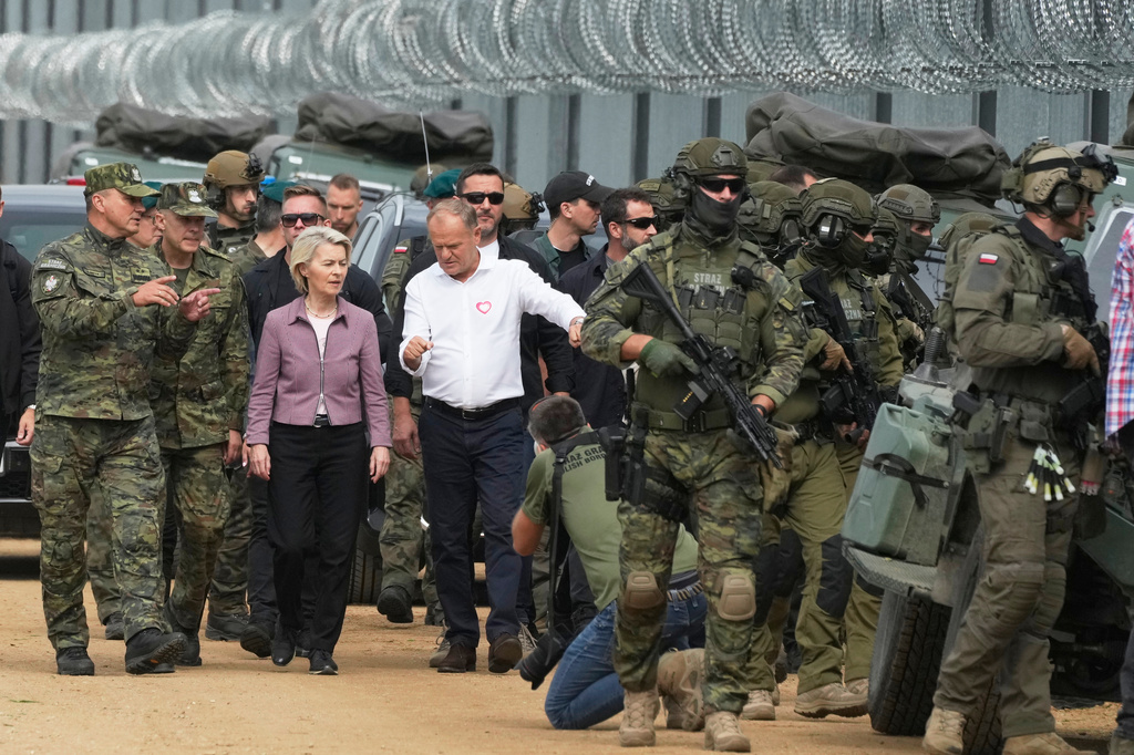 FILE - Polish Prime Minister Donald Tusk , center right, and European Commission President Ursula von der Leyen, center left, walk next to Border Guard personnel during their visit to the Polish-Belarus border, in Krynki, Poland, Aug. 31, 2025. (AP Photo/Czarek Sokolowski, file)