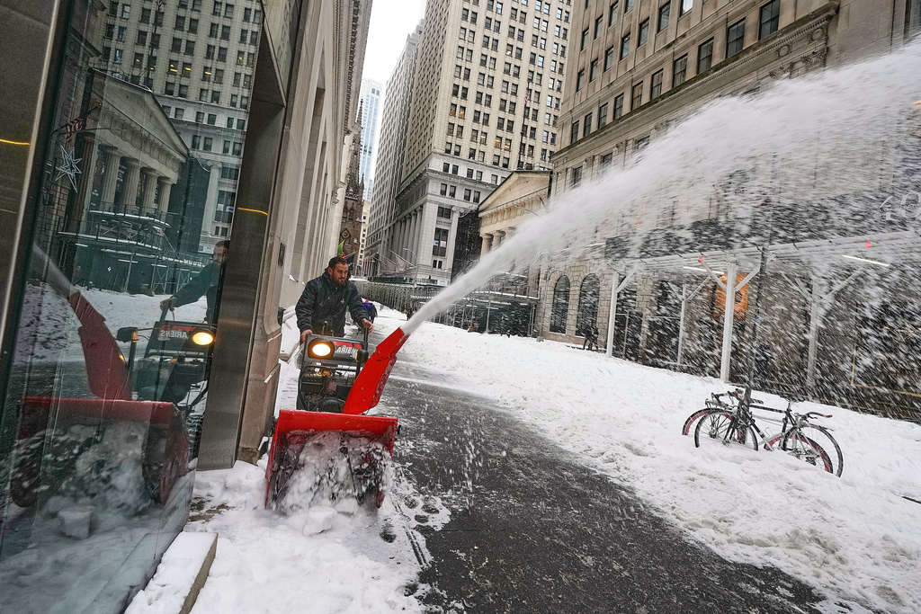 A worker uses a snow blower on Wall Street, in New York, Monday, Jan. 26, 2026. (AP Photo/Richard Drew)